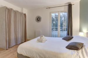 een slaapkamer met een groot wit bed met een teddybeer erop bij Le Petit Nid - Montigny in Montigny-le-Bretonneux