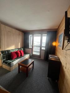 a living room with a couch with red pillows at Studio 941-Particulier-Résidence L'Ours Blanc-Alpe d'Huez-Centre Station in L'Alpe-d'Huez