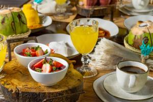 una mesa cubierta con tazones de fruta y una taza de café en Pousada Mirai, en São Miguel dos Milagres