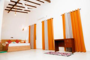 a bedroom with orange curtains and a bed and a desk at Blue Sky Villa Ahangama in Ahangama +26 photos