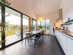 een keuken en eetkamer met een tafel en stoelen bij Cozy forest villa on the water near Harderwijk in Zeewolde