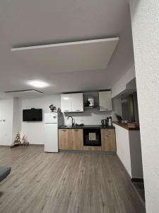 an empty kitchen with a white refrigerator in a room at Apartma Studio Jana in Kranjska Gora