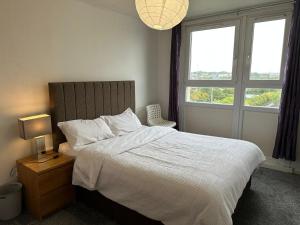 a bedroom with a white bed and a window at Private room in Glasgow City Center in Glasgow