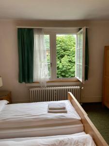 1 dormitorio con cama y ventana grande en Hotel National, en Wattwil