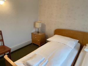 a bedroom with a bed and a lamp on a night stand at Hotel National in Wattwil