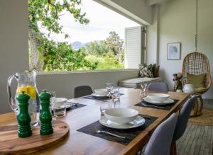 un tavolo di legno con piatti e bicchieri di Collection Luxury Accommodation: 7 On Murray Apartment 7 a Stellenbosch