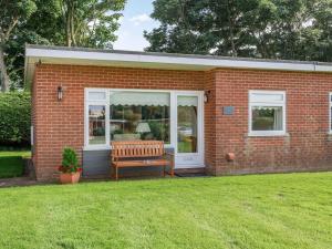 a brick house with a bench in a yard at 2 Bed in Mundesley 83661 in Mundesley
