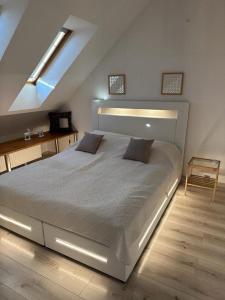 a bedroom with a large white bed in a attic at Apartament Aesthetic in Tychy