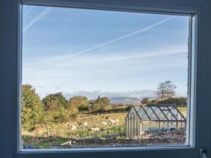 a window with a view of a field and a building at 2 Bed in Ravenglass SZ514 in Ravenglass