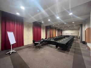 einen Konferenzraum mit Tischen, Stühlen und roten Vorhängen in der Unterkunft Hôtellerie Saint Yves in Chartres