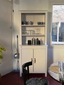 um armário branco num quarto com uma mesa em Studio en ville em Apt
