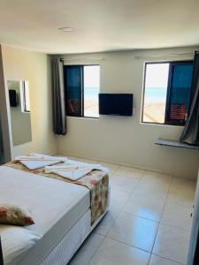 a bedroom with two beds and two windows at Iracema Mar Hotel in Fortaleza