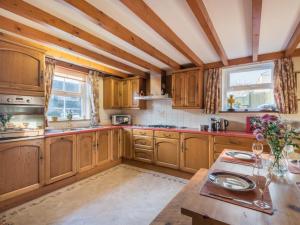 eine große Küche mit Holzschränken und einem Tisch in der Unterkunft 1 bed property in Appleby Cumbria SZ034 in Appleby