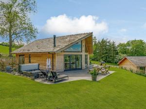 a log house with a patio and a grill at 2 Bed in Montgomery 83244 in Llandyssil