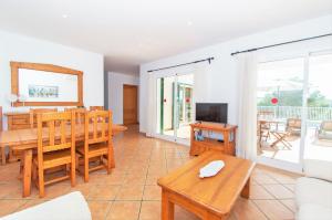 sala de estar con mesa y TV en Villa Mirador A by Sonne Villas, en Cala Galdana