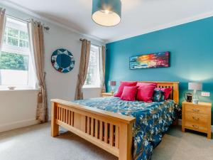 a bedroom with a bed with blue walls and red pillows at 2 Bed in Onich 83310 in Onich