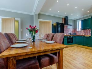 - une cuisine avec une table en bois, des chaises et des fleurs dans l'établissement 2 Bed in Onich 83310, à Onich