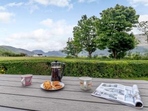 a wooden table with a coffee pot and plates of food at 2 Bed in Onich 83310 in Onich