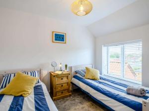 2 camas en un dormitorio con ventana en 2 Bed in Mundesley 83314 en Mundesley