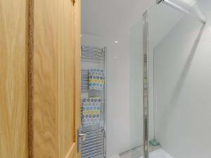 a glass closet with a rack of bottles at 1 Bed in Holywell 83270 in Whitford