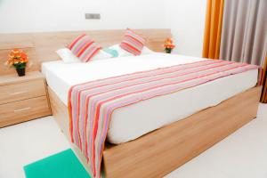 a bedroom with a bed with a striped blanket on it at Blue Sky Villa Ahangama in Ahangama