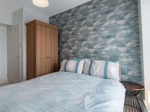 a bedroom with a bed and a brick wall at 2 Bed in Tenby 83211 in Tenby