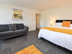 1 dormitorio con 1 cama y 1 sofá en 4 Bed in Falmouth 85825, en Gwennap