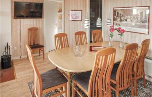 a dining room with a wooden table and chairs at Nice Home In Sjlund With 3 Bedrooms, Sauna And Wifi in Hejls