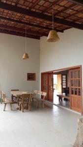 a dining room with a wooden table and chairs at Reserva Som das Águas in Caparaó Velho