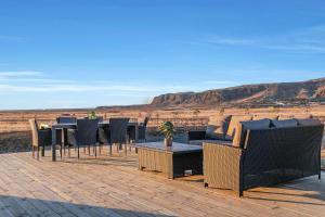 un patio con tavoli, sedie e vista sul deserto di Luxury Villa in the South - Perfect Location a Ölfus