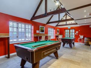 a pool table in a room with red walls at 2 Bed in Dunwich 85187 in Westleton