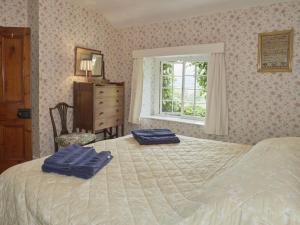 a bedroom with a bed with two blue towels on it at 3 bed in Keswick SZ422 in Applethwaite
