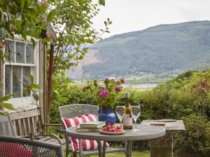 a table with a bottle of wine and flowers on a patio at 3 bed in Keswick SZ422 in Applethwaite