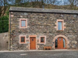 a stone building with wooden doors and windows at 3 Bed in Threlkeld SZ217 in Threlkeld