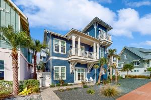 een blauw huis met een balkon en palmbomen bij A Shore Thing in Port Aransas