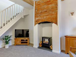 a living room with a fireplace and a tv at 1 Bed in Stoke on Tern 85516 