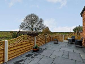 une clôture en bois sur une terrasse avec une table dans l'établissement 1 Bed in Stoke on Tern 85516, 