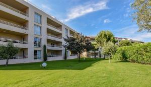 un immeuble d'appartements avec une pelouse devant lui dans l'établissement Résidence Salina Bay, à Porto-Vecchio