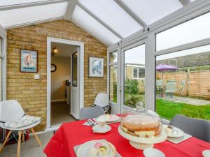 a conservatory with a table with a cake on it at 3 Bed in Sheringham 86262 in Sheringham