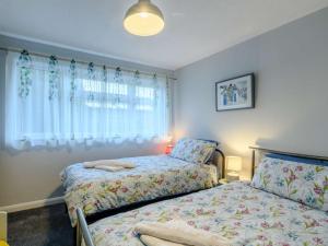 a bedroom with two beds and a window at 3 Bed in Sheringham 86262 in Sheringham