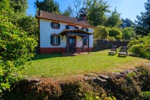 a cottage with a yard with chairs at Valle Paraizo in Camacha