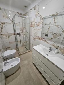 a white bathroom with a sink and a toilet at Apartamentos La Meridian in Barcelona