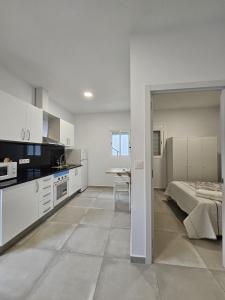 eine weiße Küche mit einem Bett und einem Tisch in der Unterkunft Apartamentos La Meridian in Barcelona
