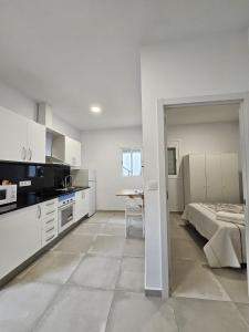 a white kitchen with a bed and a table at Apartamentos La Meridian in Barcelona