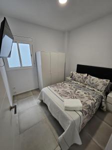 um quarto branco com uma cama e uma janela em Apartamentos La Meridian em Barcelona