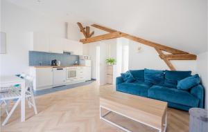 ein Wohnzimmer mit einem blauen Sofa und einer Küche in der Unterkunft 1 Bedroom Lovely Apartment In Esbly in Esbly