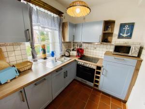 a kitchen with a sink and a microwave at Ferienhaus Waterkant in Warnemünde