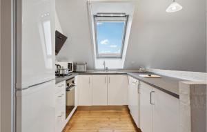 ボーゲンセにあるGorgeous Apartment In Bogense With Wifiの白いキャビネットと窓付きのキッチン