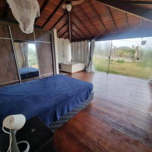 a bedroom with a blue bed and a large window at Villa Ferradura in Búzios
