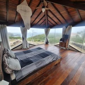 a bedroom with a bed in a room with windows at Villa Ferradura in Búzios